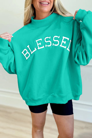 Person wearing a teal sweatshirt with 'BLESSED' text in white.