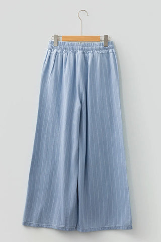Blue striped pants on a hanger against a light gray background
