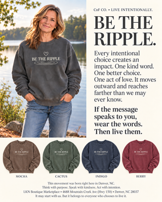 A promotional apparel listing with a large model wearing a dark charcoal sweatshirt printed with the phrase 'BE THE RIPPLE.' and four smaller color variants shown along the bottom labeled Mocha, Cactus, Indigo, and Berry.