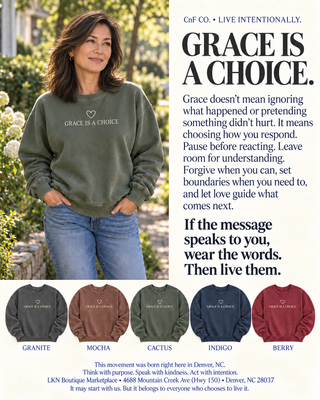A promotional apparel graphic featuring a woman outdoors wearing an olive green sweatshirt with the printed phrase 'GRACE IS A CHOICE.' and small heart icon.