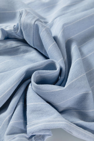 Close-up of light blue fabric with subtle stripes