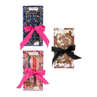 Three boxed Simply Southern blankets with navy floral, brown cow-print, and pink multicolor designs, finished with bows.